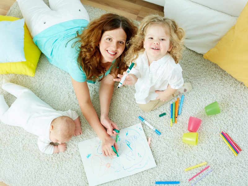 The above-view portrait of a beautiful babysitter looking after cute kids