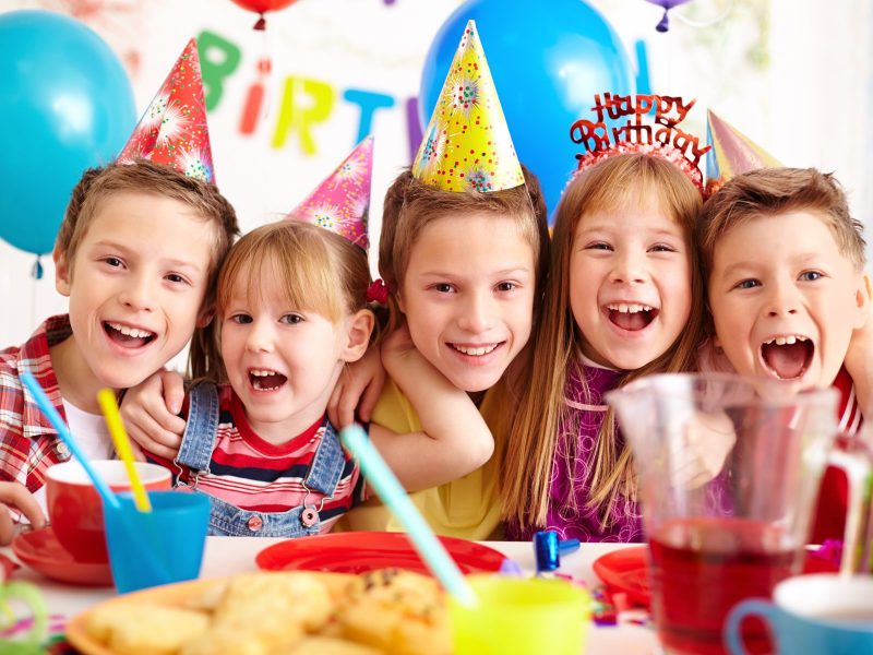 Group of adorable kids looking at camera at birthday party